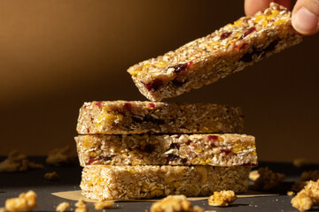 Woman takes Homemade Granola energy bar. Variety of protein granola breakfast bars, with nuts,...
