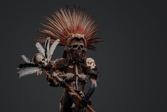 Studio shot of ancient shaman woman with painted body and plumed headdress.