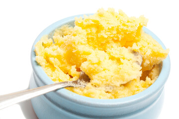 Ghee in a butter dish and spoon isolate on a white background