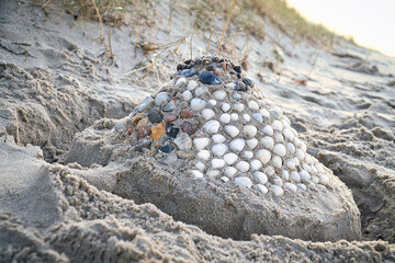 Sand castle with shells and sand. Moat around the castle in front of dunes. Denmark
