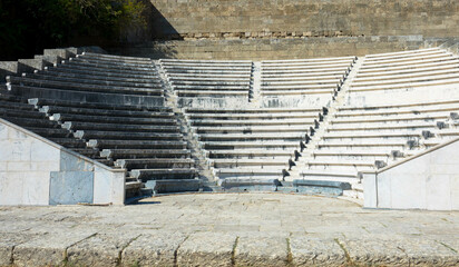 Odeon a classic greek open-air theatre.
Old theater with marble seats and stairs. The Acropolis of Rhodes. Monte Smith Hill, Rhodes island, Greece