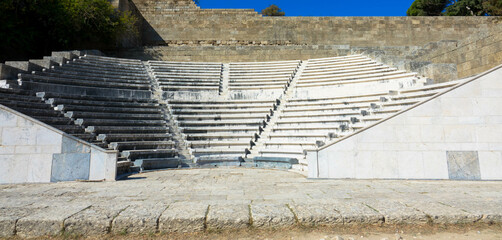 Odeon a classic greek open-air theatre.
Old theater with marble seats and stairs. The Acropolis of Rhodes. Monte Smith Hill, Rhodes island, Greece