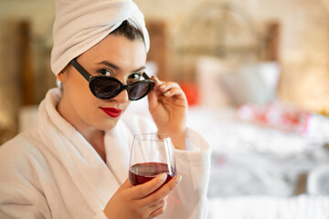 a girl in a bathrobe with a glass of wine - obrazy, fototapety, plakaty