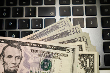 five-dollar bill with Lincoln portrait on computer keyboard