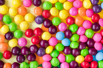 Fototapeta na wymiar Skittles candy on the colorful table, colorful sweet candy