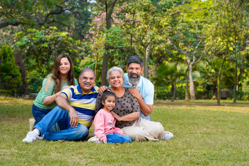 Fototapeta premium Happy indian or asian family sitting at park.
