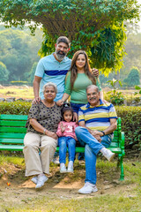 Fototapeta premium Happy indian or asian family sitting at park.