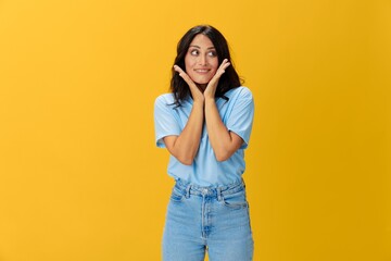 Woman signal smile with teeth emotion portrait in blue t-shirt on yellow background, hands up, surprise, lifestyle, copy space