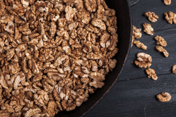 Walnut background. Peeled walnuts on a iron plate on black. walnuts a real super food full of vitamins and vegetable fats