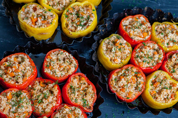 Stuffed pepper. Stewed pepper
 with rice and minced meat. Baked peppers in a cast iron pan on a black background. Healthy Romanian food.
