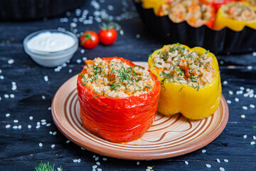 Stuffed pepper. Stewed pepper
 with rice and minced meat. Baked peppers in a cast iron pan on a black background. Healthy Romanian food.
