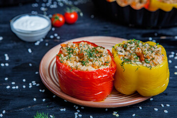 Stuffed pepper. Stewed pepper
 with rice and minced meat. Baked peppers in a cast iron pan on a black background. Healthy Romanian food.
