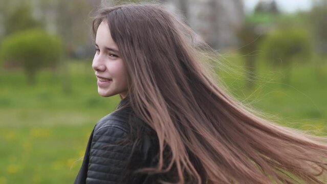 A teenage girl with long hair twirls and poses for the camera.