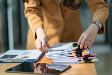 Close-up hand of Asian businesswoman arranging documents on her desk