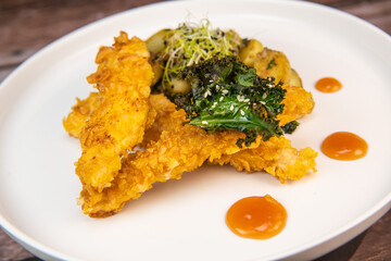 Recipe for Breaded Chicken Tenders and Potatoes with Sesame Kale Chips and Sweet and Sour Sauce. High quality photo