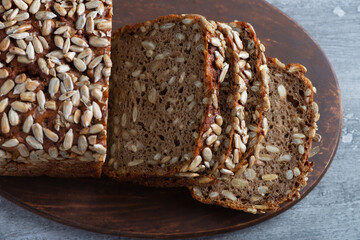 Sliced rye bread on cutting board. Whole grain rye bread with seeds
