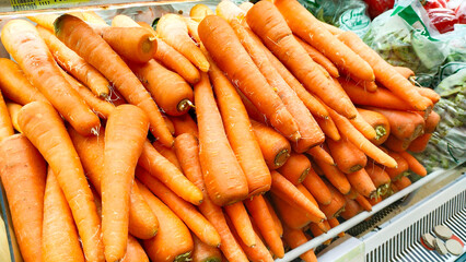 pile of fresh carrots tucked away in the vegetable section of a supermarket