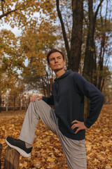 Naklejka na ściany i meble Fit male runner stretching legs and doing exercises while training on sunny day in nature in autumn 