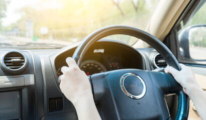 Hands female driving in her car.