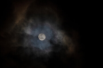 Naklejka na ściany i meble Pleine lune blanche illuminant les nuages épais d'un ciel orageux menaçant d'une nuit noire d'automne.