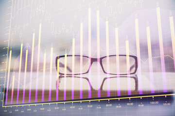 Financial graph hologram with glasses on the table background. Concept of business. Double exposure.