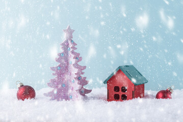 Fototapeta premium New Year greeting card with Christmas tree and decorative house in snow. Xmas background with copy space