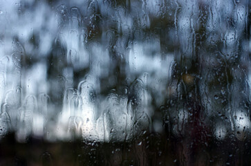 Rain drops on window glasses surface with bokeh background.