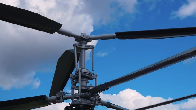 Stationary coaxial rotor of helicopter and blue, cloudy sky. A pair of gray and black propellers mounted in parallel on a helicopter. Helicopter blades. Upper and lower main propeller of an aircraft.