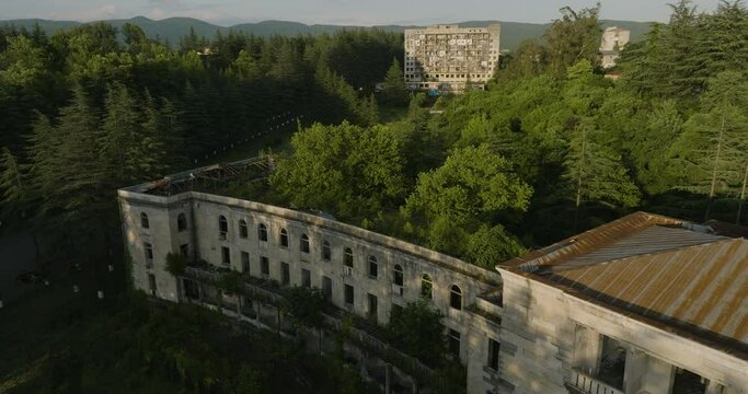 Ruins Of The Old Soviet Sanatorium With Green Trees In Tskaltubo, Georgia - aerial drone shot