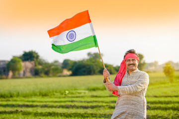 Indian farmer holding indian flag at agriculture field.