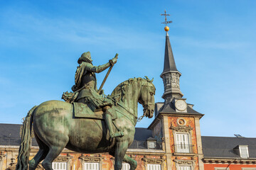 Fototapeta na wymiar Bronze statue of King Philip III on Horseback in Plaza Mayor (main square), and the Casa De La Panaderia (house of the bakery, 1619), ancient palace in Madrid downtown, Spain, southern Europe. 