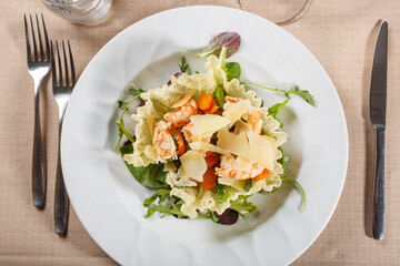 Cestino di riso con gamberi freschi, verdure e scaglie di parmigiano servito in un ristorante elegante come antipasto