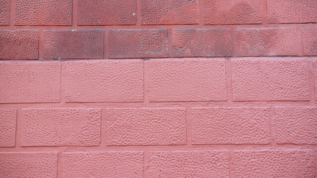 Muro de bloques pintado de rosa y granate