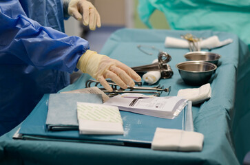 Health care personnel preparing surgical instruments on the sterile table and with sterile gloves