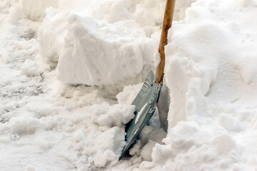 Shoveling snow in winter, Metal shovel in the snow