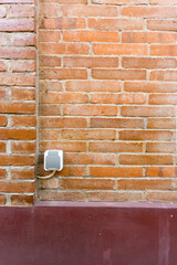 the power outlet is in a city park with red brick walls