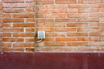 the power outlet is in a city park with red brick walls