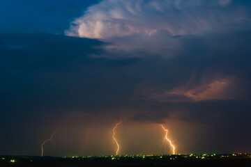 Naklejka na ściany i meble Panoramic view of a storm cloud illuminated by lightning flashes