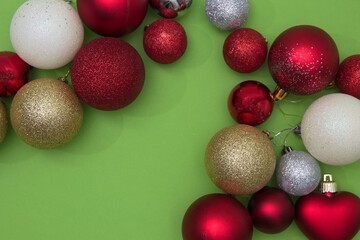 Christmas tree decorations in various colors on a green background with copy space. New Year's scene setting.