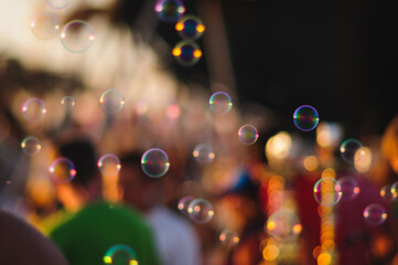 A lot of people celebrate together and enjoy the many soap bubbles in the evening at sunset.