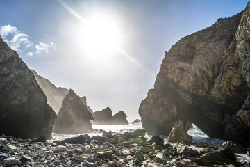 Cliffs, sharp spectacular rocks rising from the ocean. waves. Ursa sandy beach under the cliff. Sunny day. Horizontally - obrazy, fototapety, plakaty