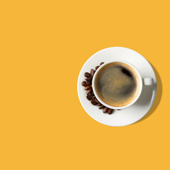Aromatic coffee in white cup on yellow background, top view. Space for text
