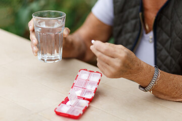 Senior woman take pills from box. Healthcare and old age concept with medicines. Medicaments on table