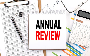 ANNUAL REVIEW text on notebook with chart, calculator and pen