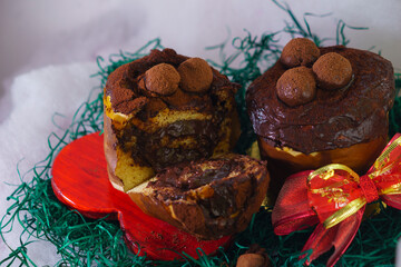Homemade Christmas panettone made with fruit, chocolate or other fillings, can be covered, a culinary resource for the Christmas season, served alongside decorations with Santa Claus and donuts, 