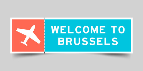 Orange and blue color ticket with plane icon and word welcome to brussels on gray background