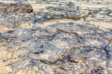 Sandy and rocky coast . Volcanic rocks on the ocean shore 