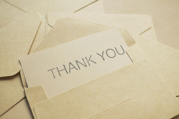 thank you message and envelope on wooden table 