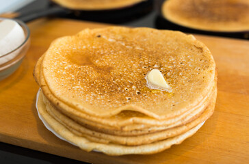 hot golden pancakes made of grain flour in the kitchen on a plate