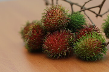 rambutan fruit which is reddish green in color having sweet taste isolated on table. Food concept photo.
